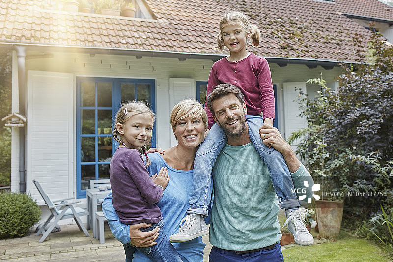 幸福的一家四口在自家门前的合影图片素材
