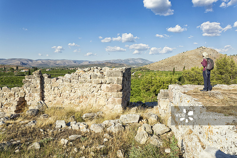 希腊伯罗奔尼撒半岛梯林斯考古遗址的巨石城堡墙，游客正在观赏图片素材