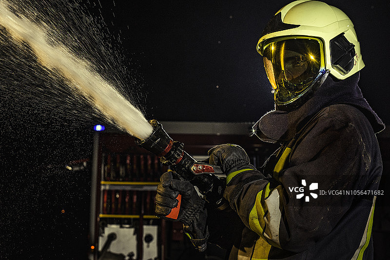 消防员使用消防水带喷水灭火特写图片素材