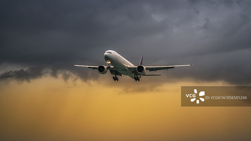 在壮观的日落云层之上飞行的商用飞机图片素材