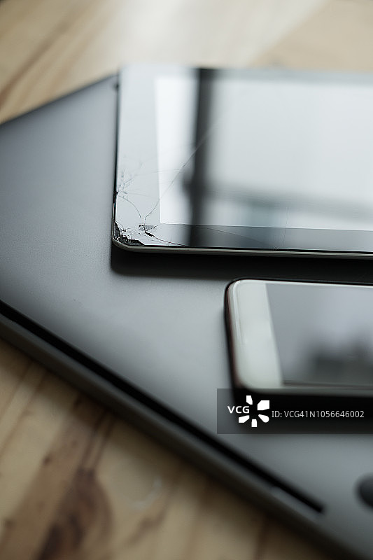 工作台面上带有裂纹平板的智能手机图片素材