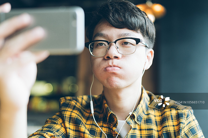 在咖啡馆享受咖啡休息的亚洲青年男子图片素材