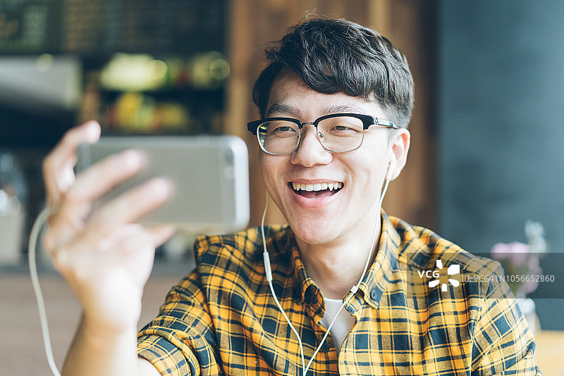 在咖啡馆享受咖啡休息的亚洲青年男子图片素材