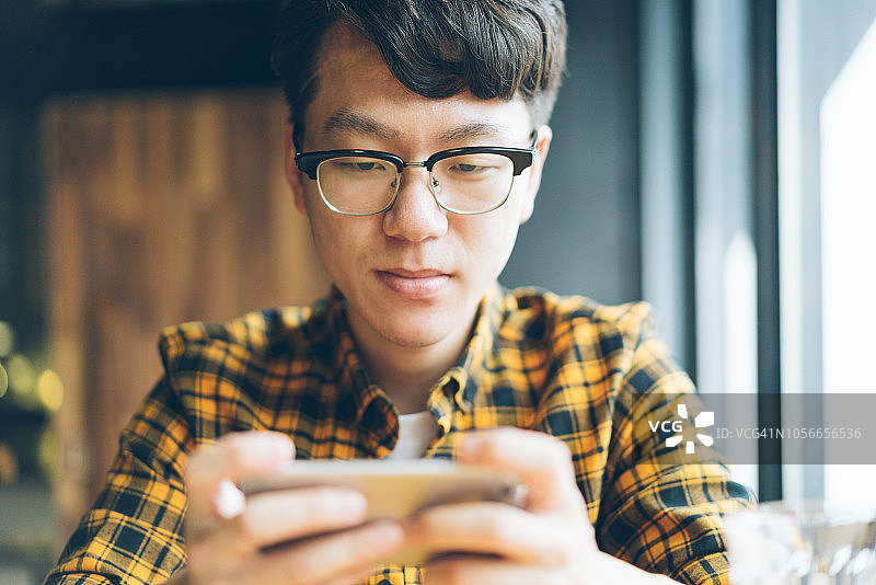 在咖啡馆享受咖啡休息的亚洲青年男子图片素材