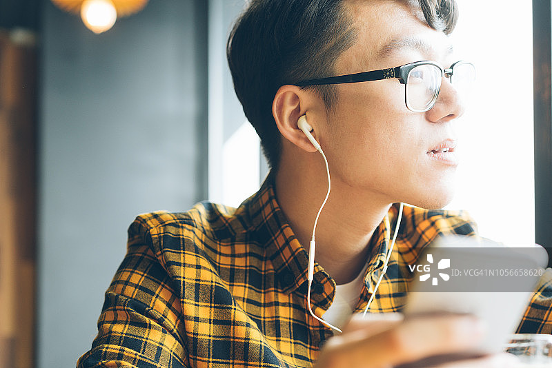 在咖啡馆享受咖啡休息的亚洲青年男子图片素材