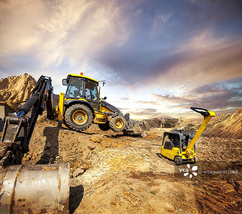 建筑工地上的大型挖掘机和压板机图片素材