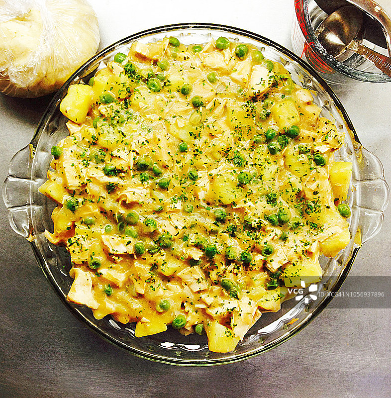 准备好的鸡肉馅饼，配烤鸡、土豆、青豆、洋葱和芹菜 - 塑料包装面团和测量用具图片素材