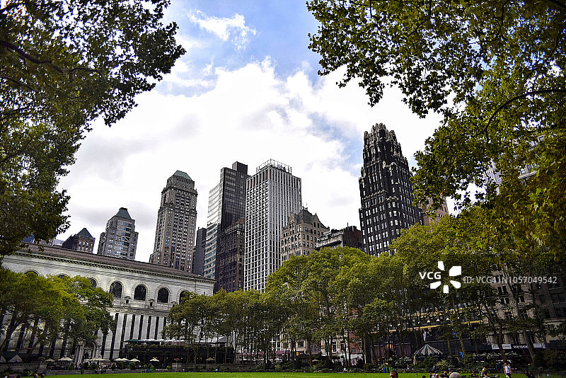 被摩天大楼环绕的布莱恩特公园，背景是纽约图书馆图片素材