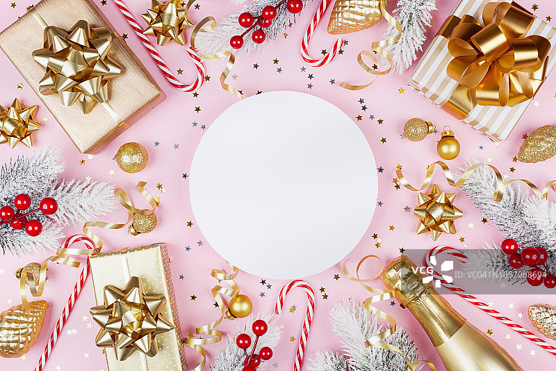 粉色背景上的圣诞节装饰、雪松树、礼品盒、香槟和空白卡片图片素材