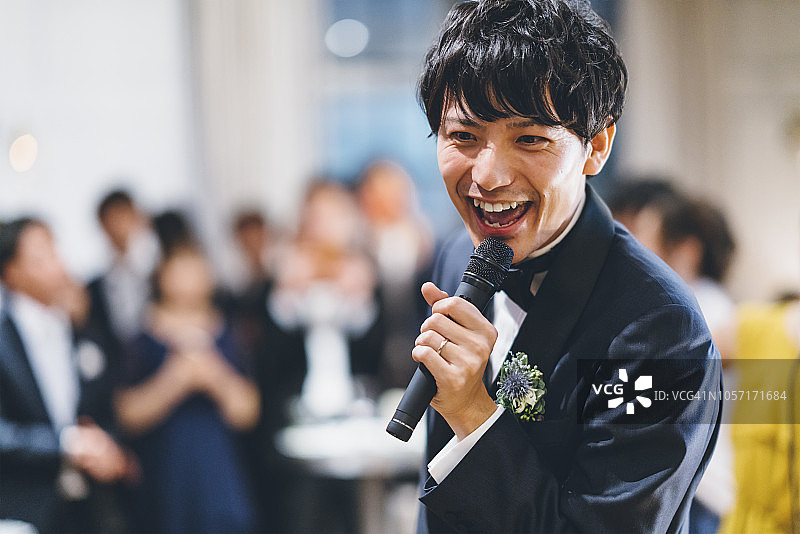 穿着燕尾服高兴唱歌的年轻亚洲男人图片素材