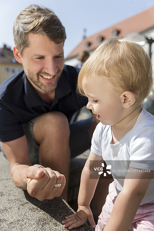 户外，父亲对着小女儿握拳微笑图片素材