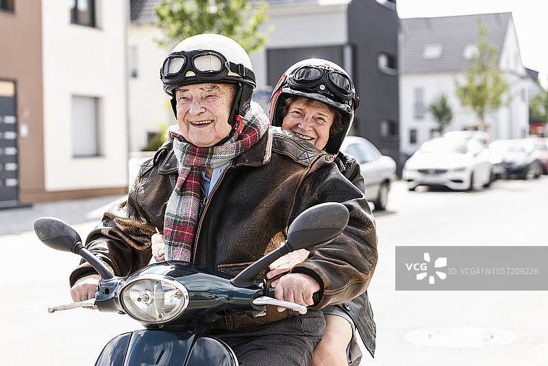快乐的老年夫妇骑着摩托车图片素材