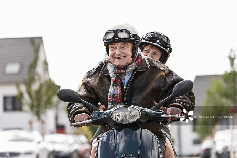 快乐的老年夫妇骑着摩托车图片素材