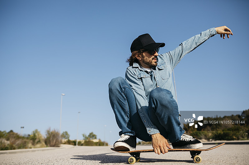 戴牛仔帽的时尚男人玩滑板图片素材