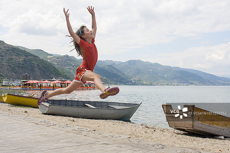 在阿尔巴尼亚波格拉德茨的奥赫里德湖上跳跃，快乐的小女孩图片素材