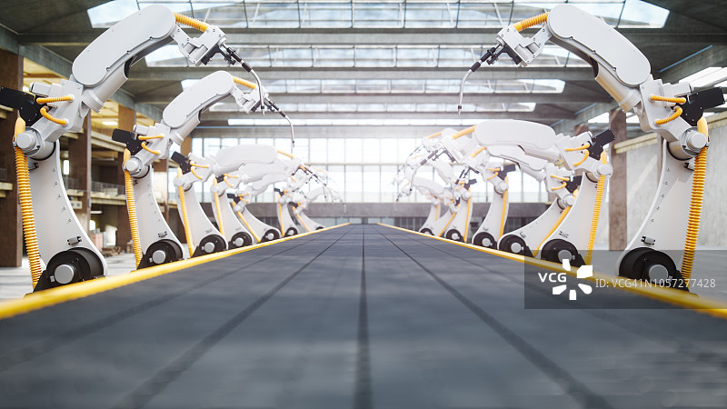 自动化工厂中的焊接机器人和传送带图片素材