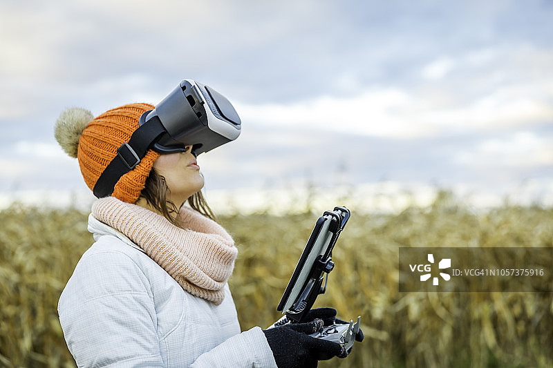 使用平板电脑和VR眼镜操控无人机的女飞行员图片素材