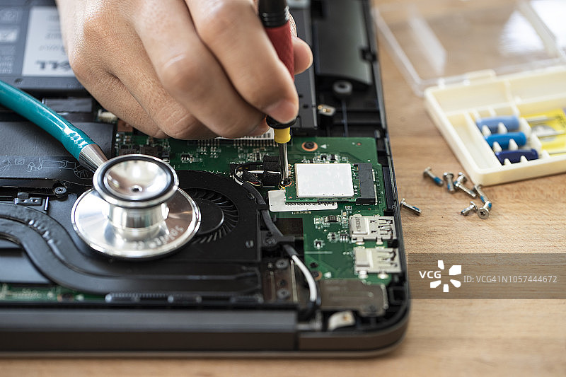 电脑维修员检查笔记本电脑清洁散热膏图片素材