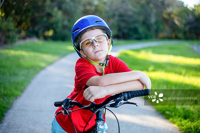 澳大利亚男孩骑自行车吃冰淇淋图片素材