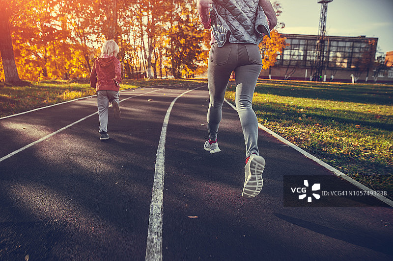 女人和男孩在体育场跑步图片素材