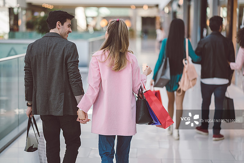 情侣手牵着手在购物中心购物图片素材