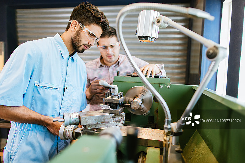 年轻教授指导学生操作车床图片素材