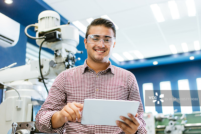 用平板电脑做笔记的年轻拉丁美洲工程师图片素材