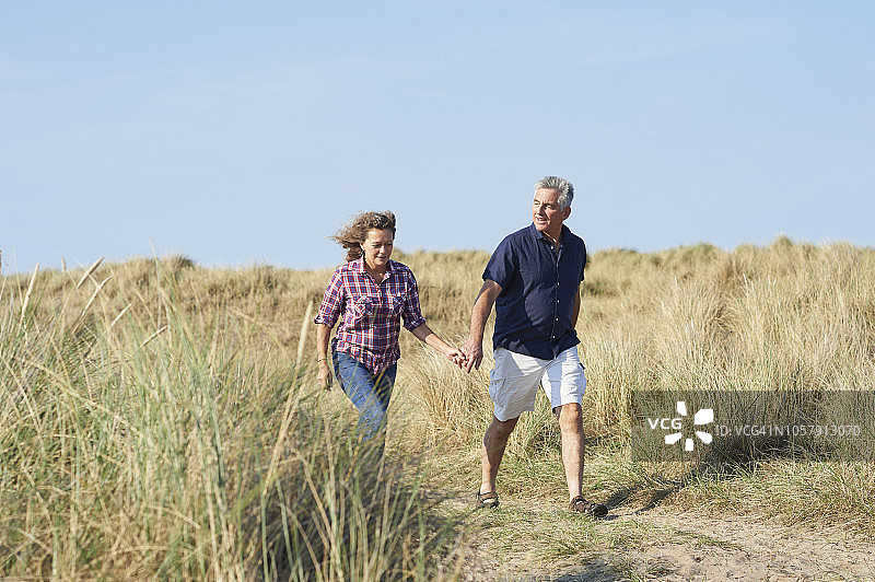 中年夫妇在海岸边散步图片素材