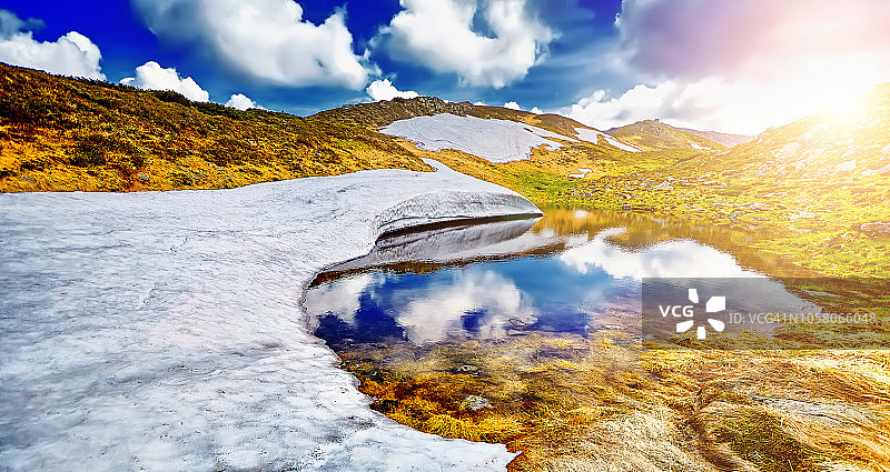 壮丽的山景：绚丽日落映衬下的多云天空图片素材