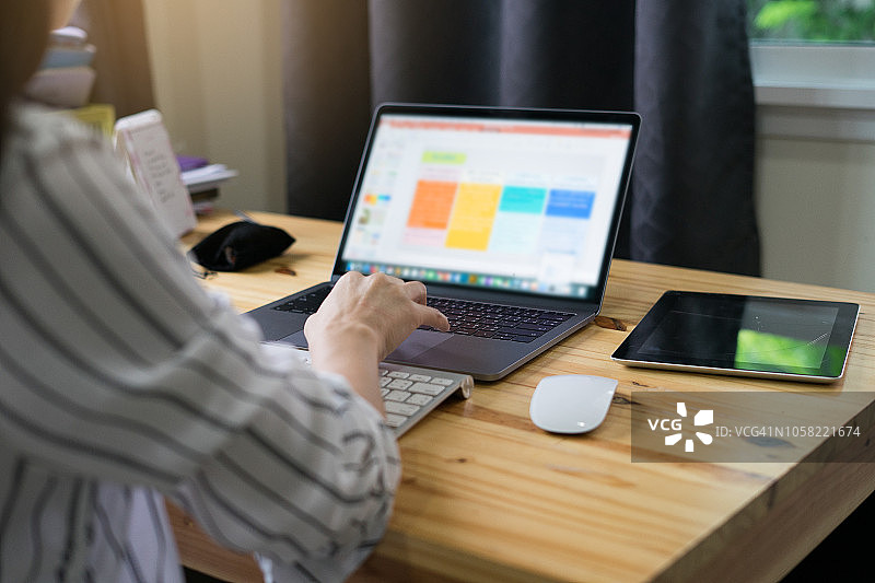 女大学生在工作区用笔记本电脑创业做笔记图片素材