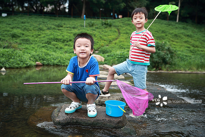儿童在小溪边钓鱼图片素材