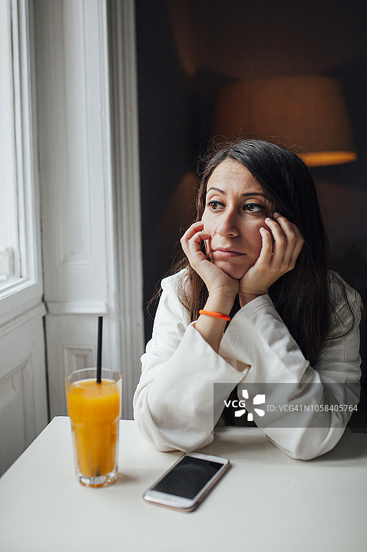 在咖啡馆喝果汁的年轻女人图片素材