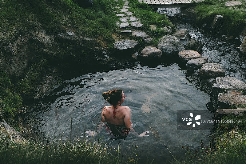 在冰岛野生温泉中休息的女人图片素材