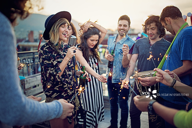 朋友们在屋顶露台上举办音乐会庆祝图片素材