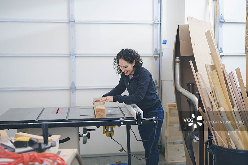 女人用台锯切割木头图片素材