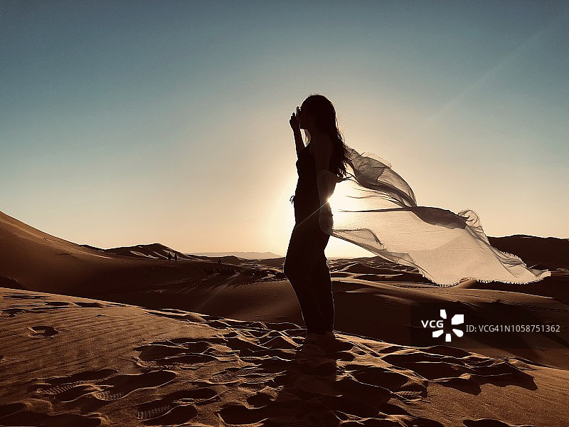在有着奇幻日落的沙漠中的女孩图片素材