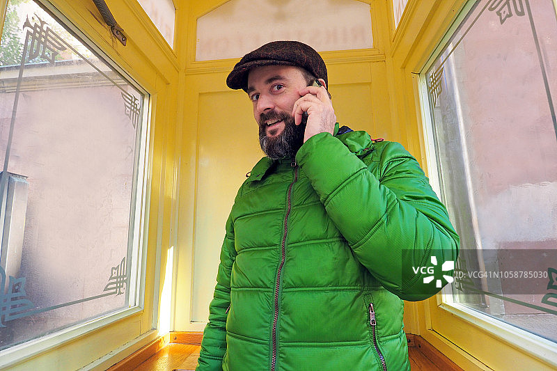 男子在斯德哥尔摩传统电话亭里打电话图片素材