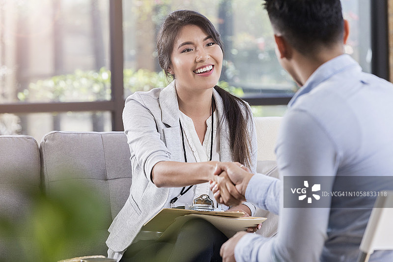 心理健康专业人士与患者在会面前热情握手图片素材