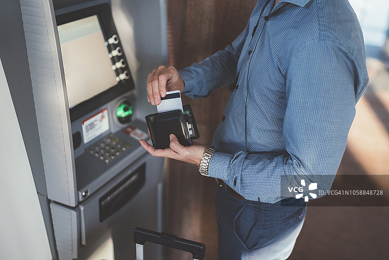 在机场ATM机上使用信用卡的乘客图片素材
