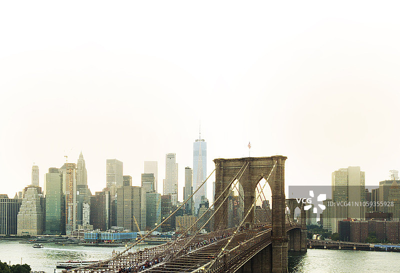 日落时分，行人与曼哈顿天际线的布鲁克林大桥航拍图片素材