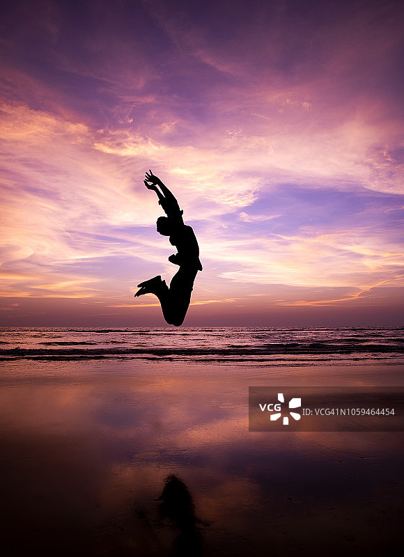 男子在海滩上跳跃的剪影图片素材
