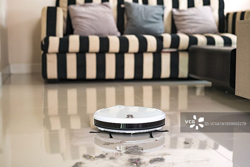 在毛毯上工作的扫地机器人图片素材