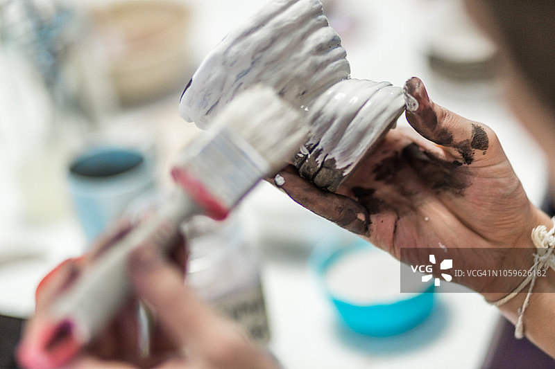 男性在陶瓷作品上绘画的双手特写图片素材