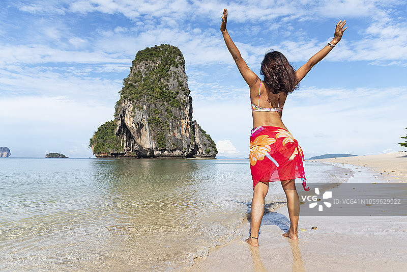 在莱利海滩张开双臂的女人图片素材
