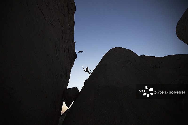 戴帽猕猴在巨石间跳跃图片素材