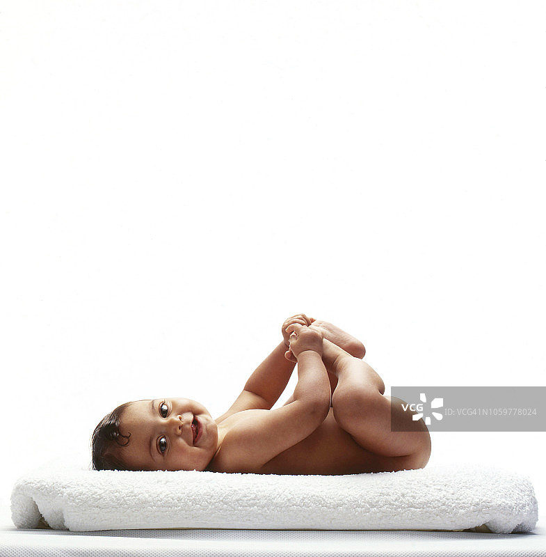 快乐的宝宝抱着脚图片素材