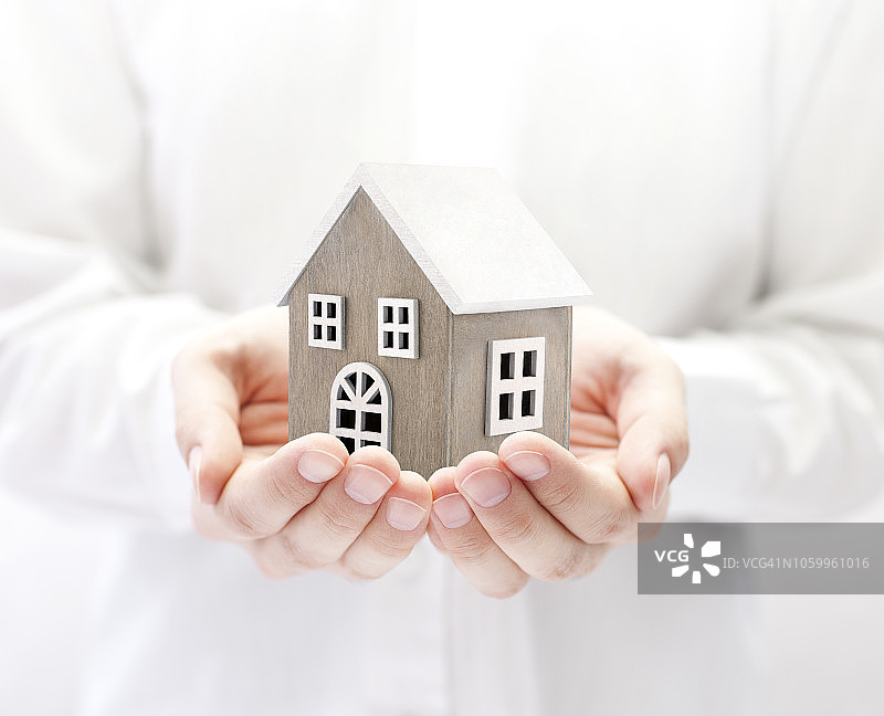 手中的小木制玩具房子图片素材