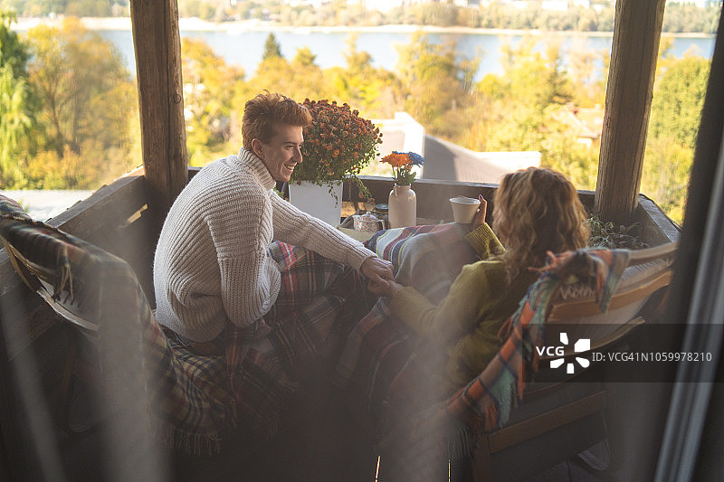 微笑情侣在阳台上享受轻松的早晨图片素材