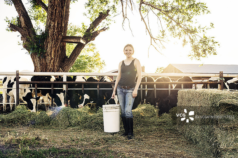 年轻女性农场工人与牛群肖像图片素材