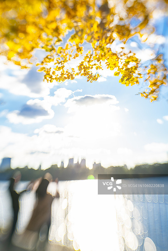 人们在纽约中央公园秋色中看曼哈顿摩天大楼图片素材